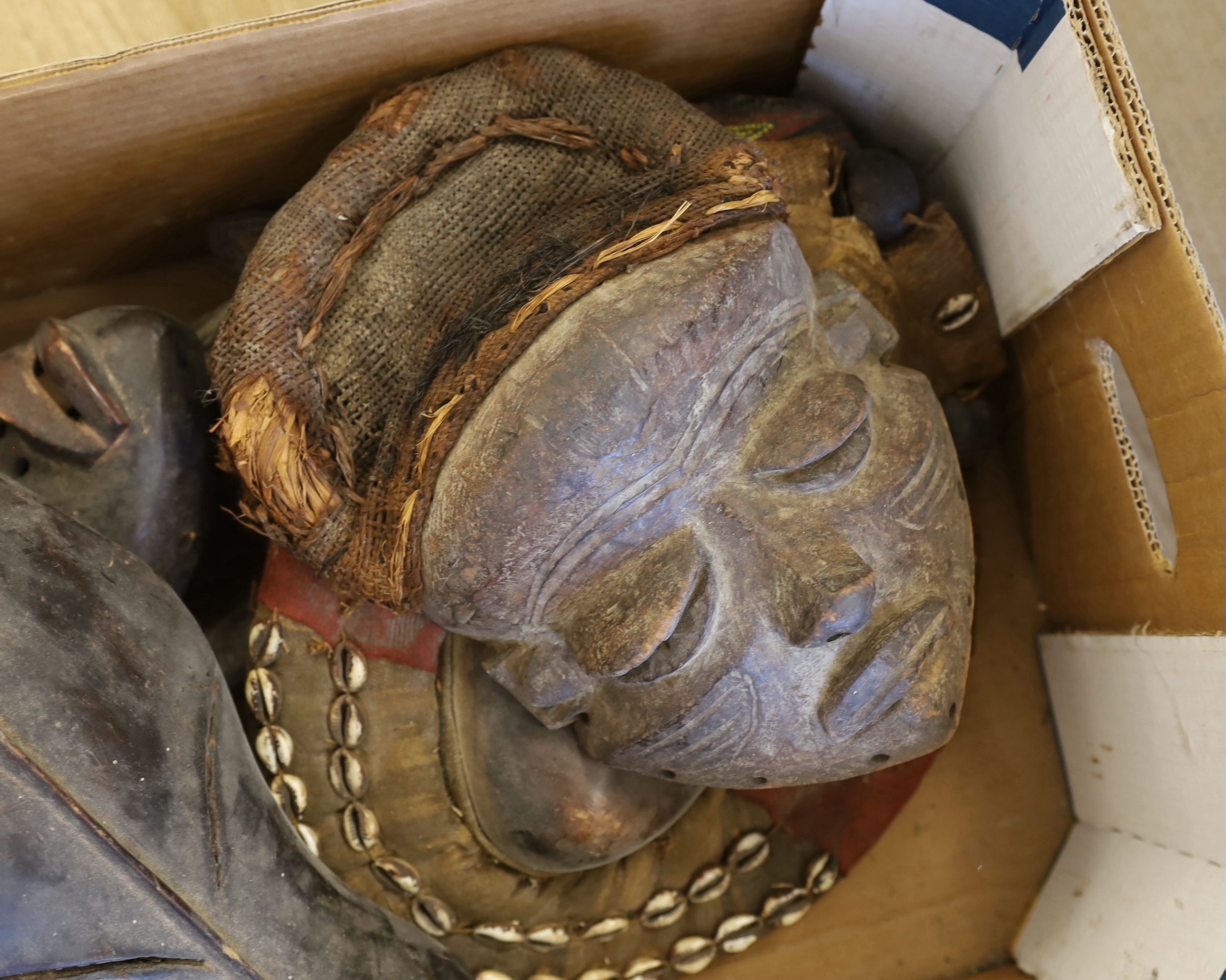 Six African Tribal masks, some decorated with shell and coloured beads, largest 70cm